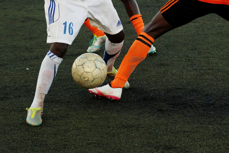 close up two players contesting the ball in a football match